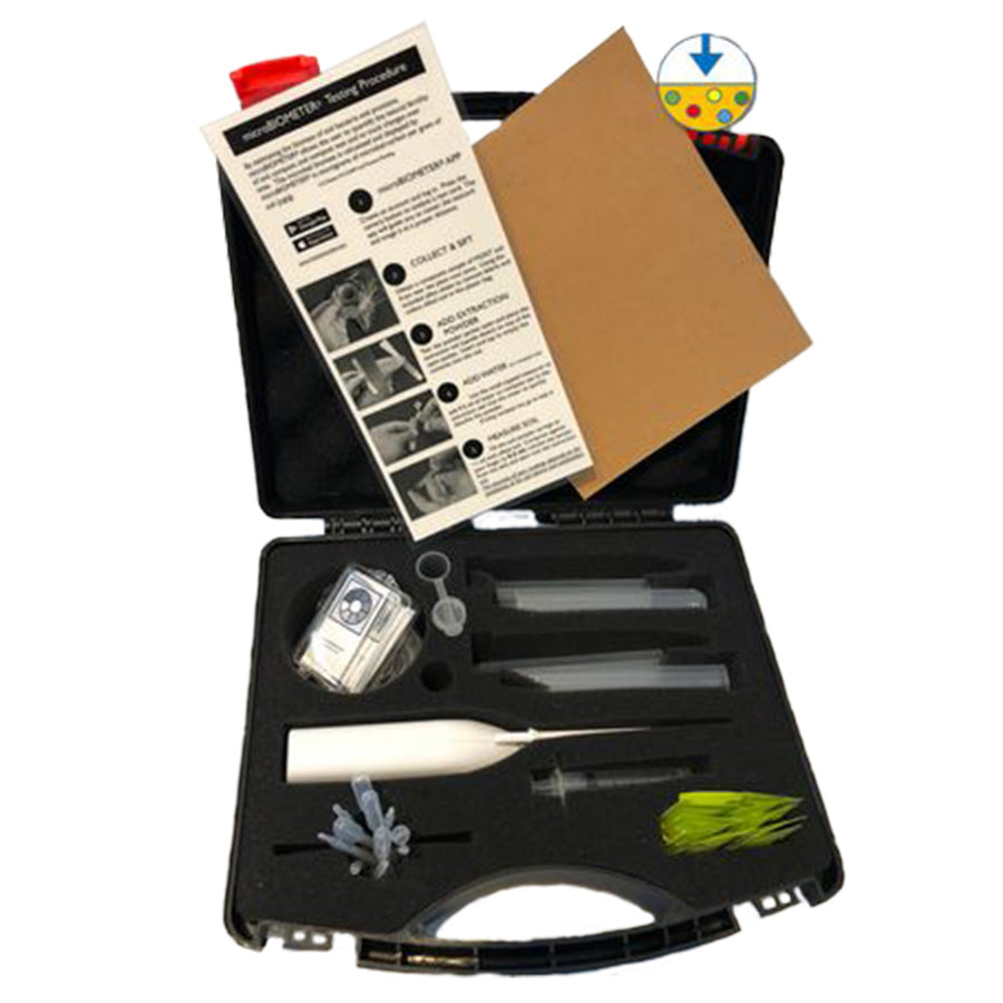A photograph of the microBIOMETER starter kit containing the microBIOMETER, soil sampler, whisker, measuring vial, 10 plastic extraction tubes,10 plastic pipettes, 10 test cards, 10 sachets of extraction powder, and a testing procedure instruction sheet, in a black carry case, on white background.